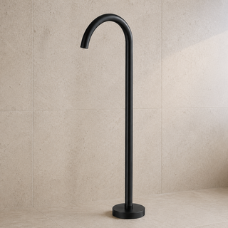 Black freestanding bathtub faucet against a beige tiled wall.