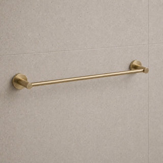brushed brass towel bar mounted on a beige tiled wall