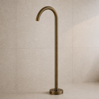 Brass freestanding gooseneck bathtub tap against a beige tiled wall.