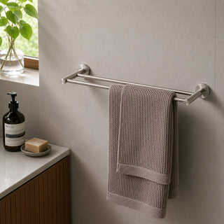 brushed nickel double bathroom towel holder on a beige tile wall with a timber vanity