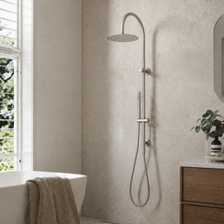 Modern nickel shower system mounted on a textured wall in a bathroom.