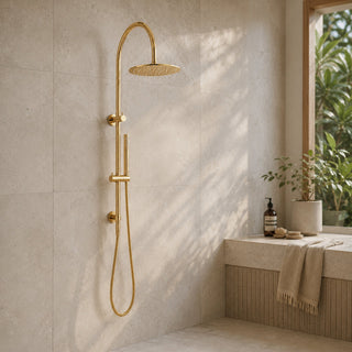 polished gold gooseneck rain shower head set in a modern bathroom with beige tiles and an indoor plant